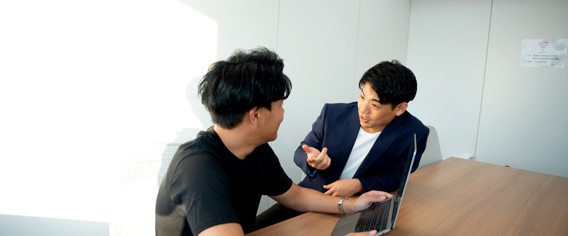 ノートPCを囲んで話し合うメンバー